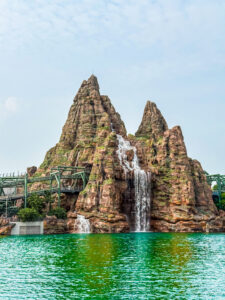 La montagne et la cascade emblématiques de la zone Jurassic World Isla Nublar à Universal Studios Beijing, avec les rails des montagnes russes.